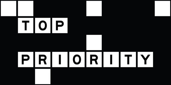 Alphabet letter in word top priority on crossword puzzle background