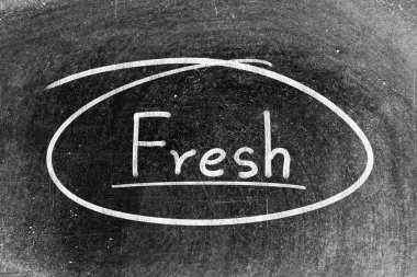 Beyaz tebeşirle yazılmış el yazısı. Tahta arka planda taze ve daire şeklinde.