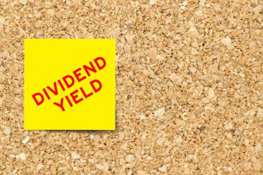 Mantar pano arka planında kelime temettür verimi içeren sarı not kağıdı