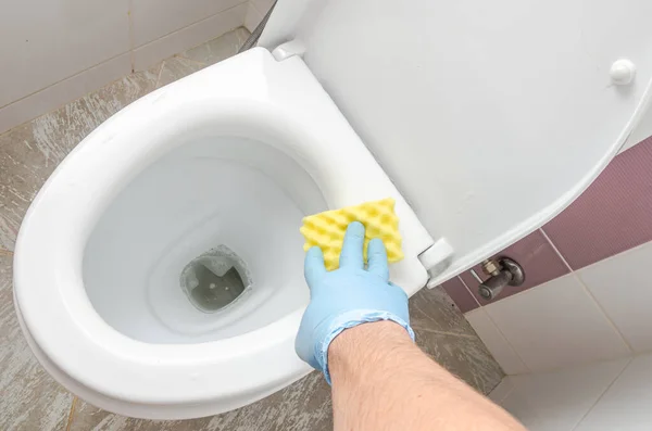 stock image A housekeeper washes a dirty toilet bowl with a cleaning agent in the toilet