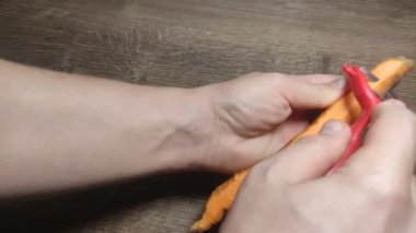 Şef havuçları soyar.