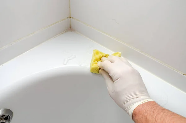 バスルームで家庭用化学物質で浴槽を洗う家政婦 — ストック写真