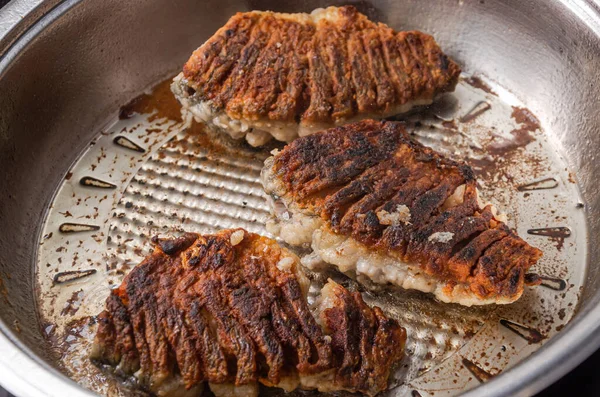 stock image The cook fries crucian fish in a frying pan