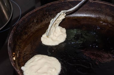 Aşçı tavada krep pişiriyor.