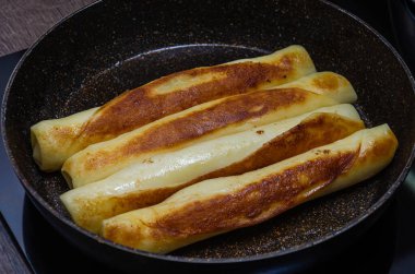 Aşçı kahvaltıda tavada krep kızartıyor.