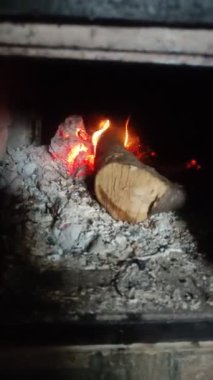Dikey video. Yakacak odun ocakta ateşle yanıyor.