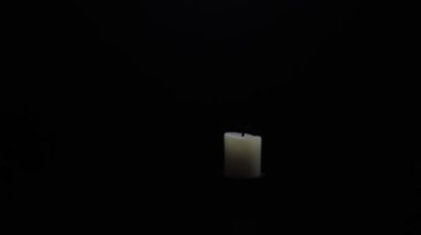 A man ignites a fire with a lighter on candles isolated on a black background