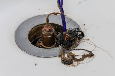 Wash basin drain clogged with hair and debris