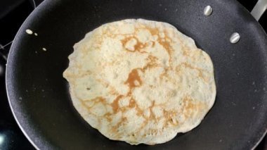 Aşçı tavada krep pişiriyor.