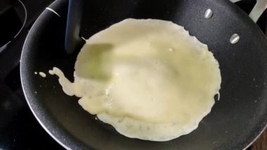 Aşçı tavada krep pişiriyor.