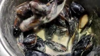 Şef mavi peynir soslu midye pişiriyor.