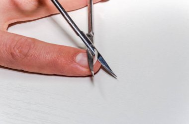 Manikür makası bir manikürcüde tırnak kesiyor.