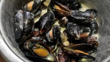 Şef mavi peynir soslu midye pişiriyor.