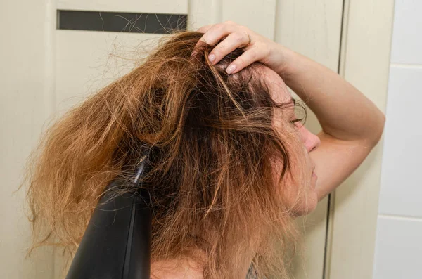 用吹风机吹干头发的年轻女人 — 图库照片