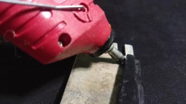 Usta, parçaları yapıştırıcı çubuğuyla yapıştırıyor.