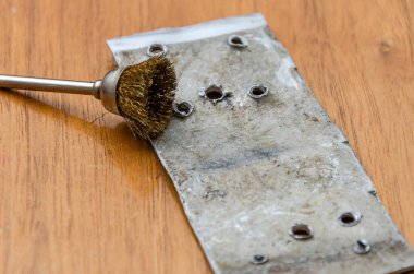 Usta metali elektrikle çoklu bir aletle parlatıyor.