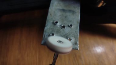 Usta metali elektrikle çoklu bir aletle parlatıyor.