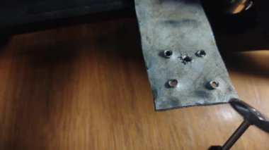 Usta metali elektrikle çoklu bir aletle parlatıyor.