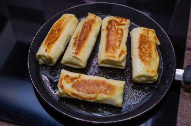 Aşçı tavada krep pişiriyor.