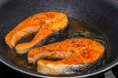 Kızartma tavasında kızarmış somon balığı bifteği.