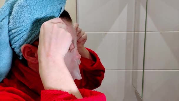 Young Woman Doing Herself Spa Beauty Treatment Laying Moisturizing Sheet — Stock Video
