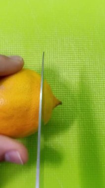 Aşçı bir limonu kesme tahtasındaki bir bıçakla keser. Dikey video