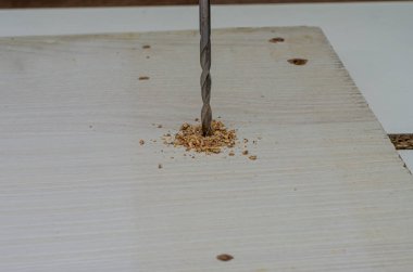 Matkapla tahta bir tahtaya delik açmış. Yakın plan.