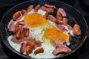 Kızarmış tavada sosisli yumurta.