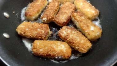 Kızartma tavasında kızartılmış balık külçeleri.