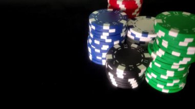 Siyah arka planda bir kumarhanede poker fişleri ve kartlar.