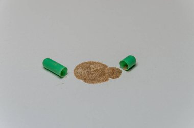 Hasta kapsül şeklinde bir ilaç tableti açıyor ve içindekileri döküyor.