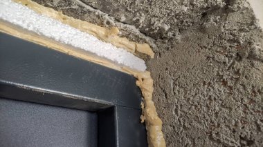 İnşaat alanında kapı kurulumu için köpük bağlanıyor
