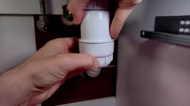 Muslukçu tıkanmış lavaboyu temizler.