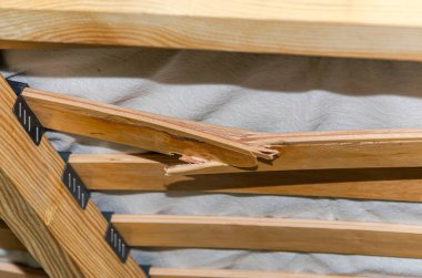 Yatağın üstünde, yatağın altında, kırık ahşap bir bölme.