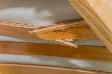 Yatağın üzerinde kırık bir tahta parçası.