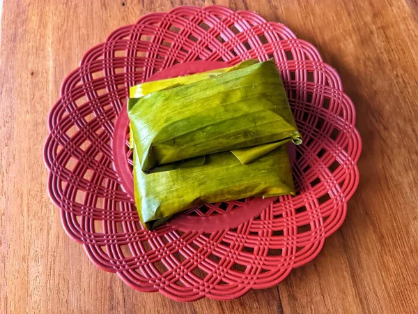 photo of a traditional Javanese, Indonesian cake made of flour and wrapped in banana leaves and then steamed which we call \