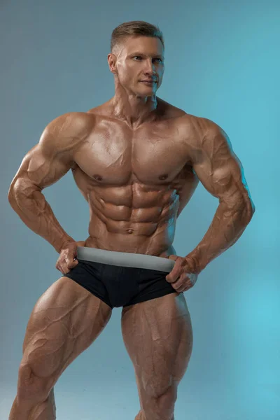 Kroppsbyggare Vuxen Muskulös Manliga Modell Poserar Tom Bakgrund Shorts Visar — Stockfoto