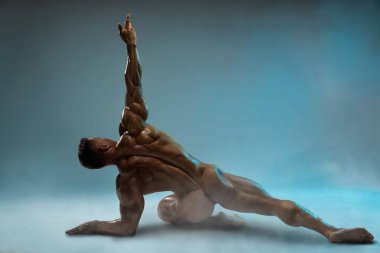 Bodybuilder adult muscular male model posing on an empty background without clothes, showing a perfect muscular back, butt and legs with a low percentage of fat