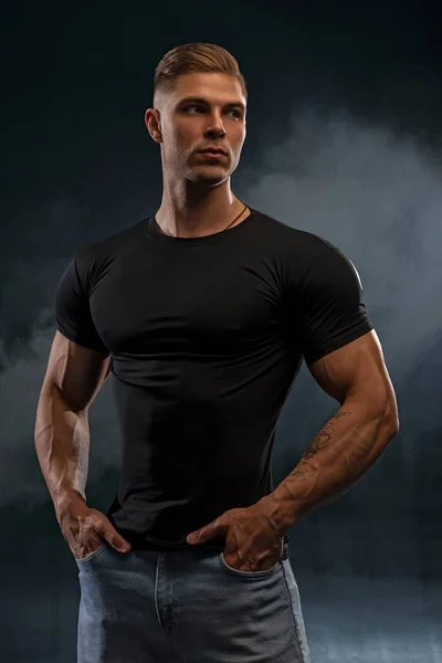 근육질 모델은 청바지와 티셔츠를 남자를 배경으로 스포츠를 유행하는 스타일의 건강하고 — 스톡 사진