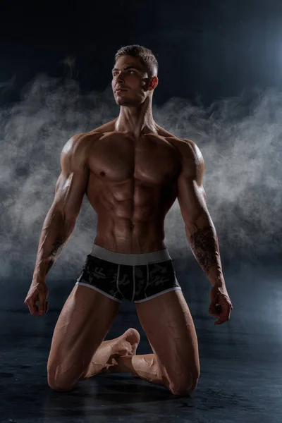 一个强壮的运动员赤身裸体地站在黑工作室里 六包腹肌的运动肌肉体 脂肪含量低 — 图库照片