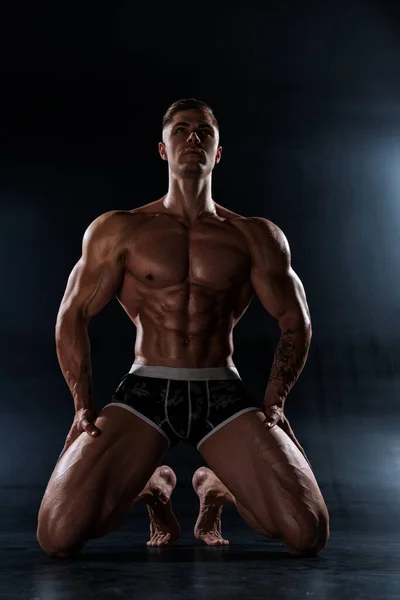 一个强壮的运动员赤身裸体地站在黑工作室里 六包腹肌的运动肌肉体 脂肪含量低 — 图库照片