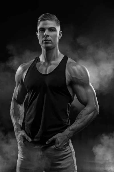 근육질 모델은 청바지와 셔츠를 남자를 뒷배경에서 바라본다 유행하는 스타일의 근육을 — 스톡 사진