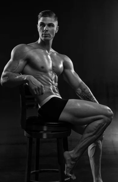 迷人的性感健美运动员在黑色背景的工作室短裤 展示了肌肉强壮的身体 身体美学的概念与健康的生活方式黑白照片 — 图库照片