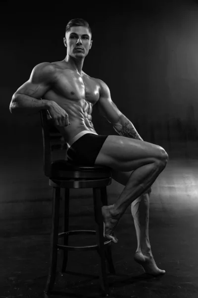 迷人的性感健美运动员在黑色背景的工作室短裤 展示了肌肉强壮的身体 身体美学的概念与健康的生活方式黑白照片 — 图库照片