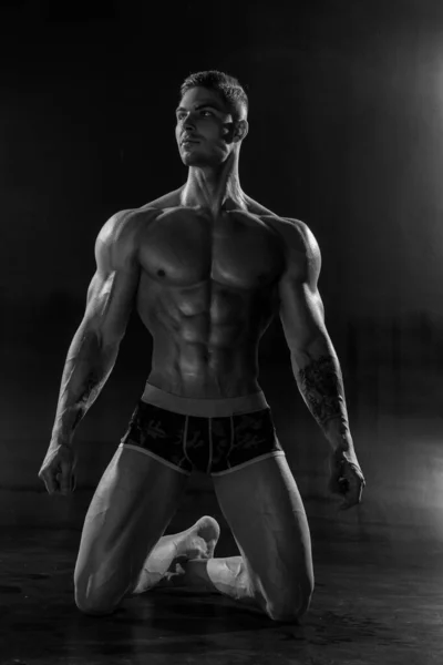 Silný Atletický Muž Pózuje Bez Košile Stojící Kolenou Černém Studiu — Stock fotografie