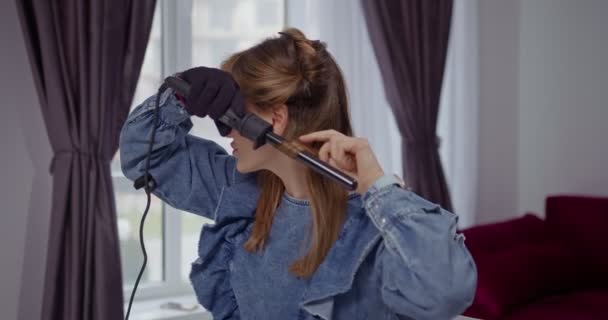 Mulher Jovem Loira Bonita Torce Seu Cabelo Com Ferro Ondulação — Vídeo de Stock