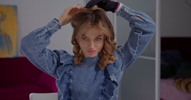 髪のスタイリングの過程でブロンドの若い女性 ストランドを再配置 家庭の毎日の髪のルーチン — ストック動画