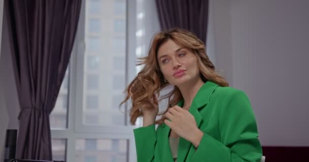 Красивая Модная Девушка Зеленой Куртке Демонстрирует Стильные Кудри Прикасается Своим — стоковое видео