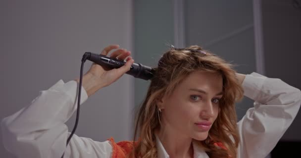 Όμορφη Ξανθιά Νεαρή Γυναίκα Στη Διαδικασία Του Styling Μαλλιών Χωρίζει — Αρχείο Βίντεο