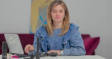 Masadaki mavi gözlü genç bayan saç stili dersi vermeye hazırlanıyor.